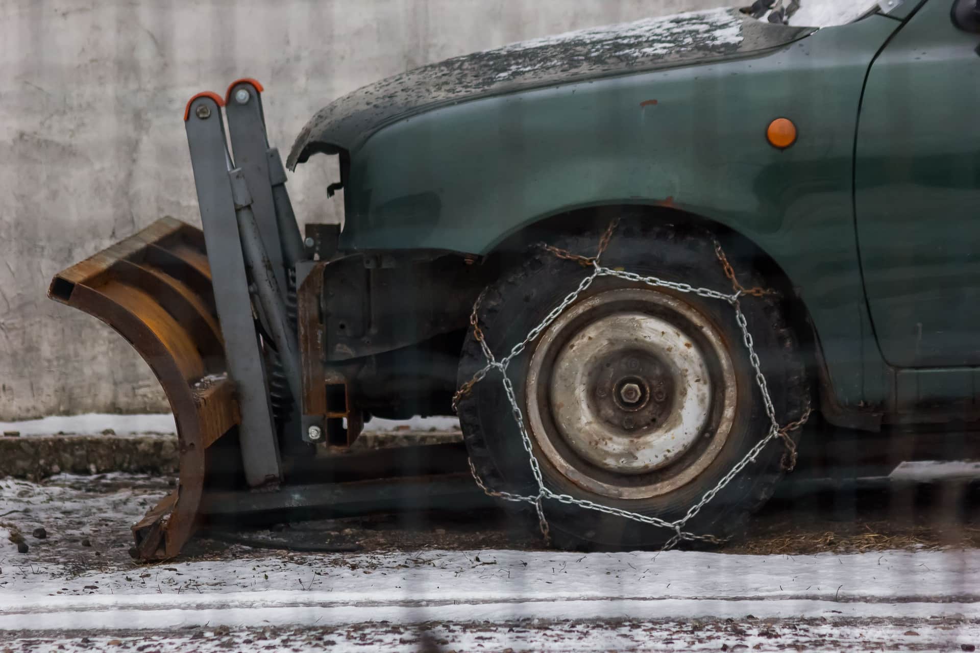 Snow chains fitted to a car tire in deep snow