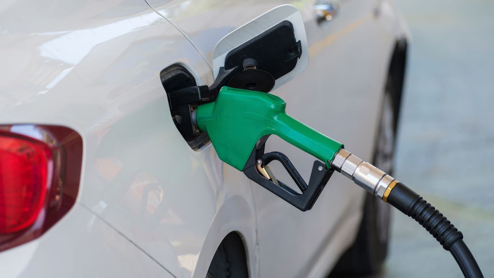 Fuel nozzle refueling a car at a gas station