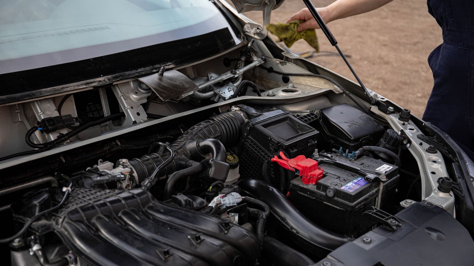 Open hood of a car with the battery and engine bay visible
