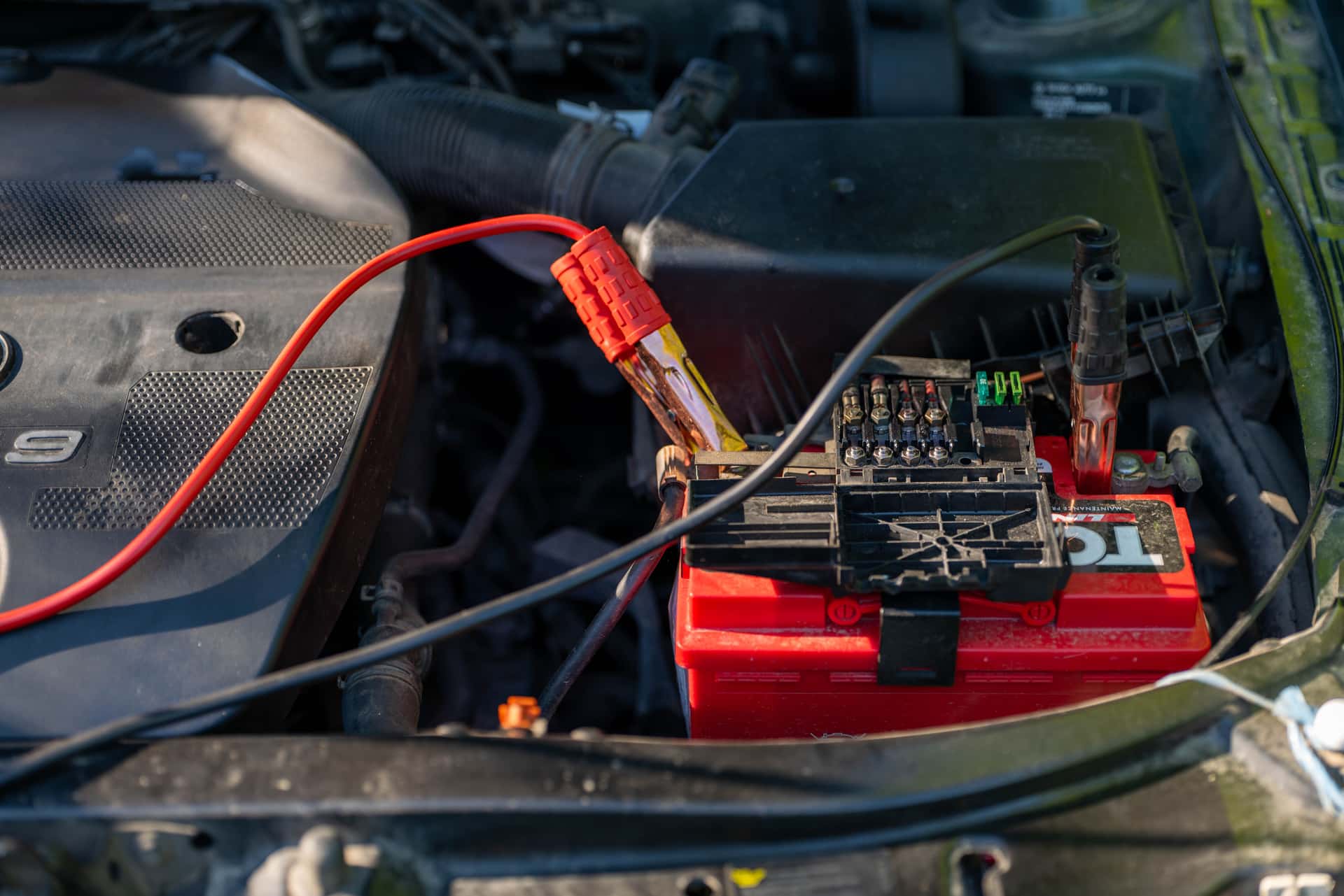 Jumper cables clamped to a car battery