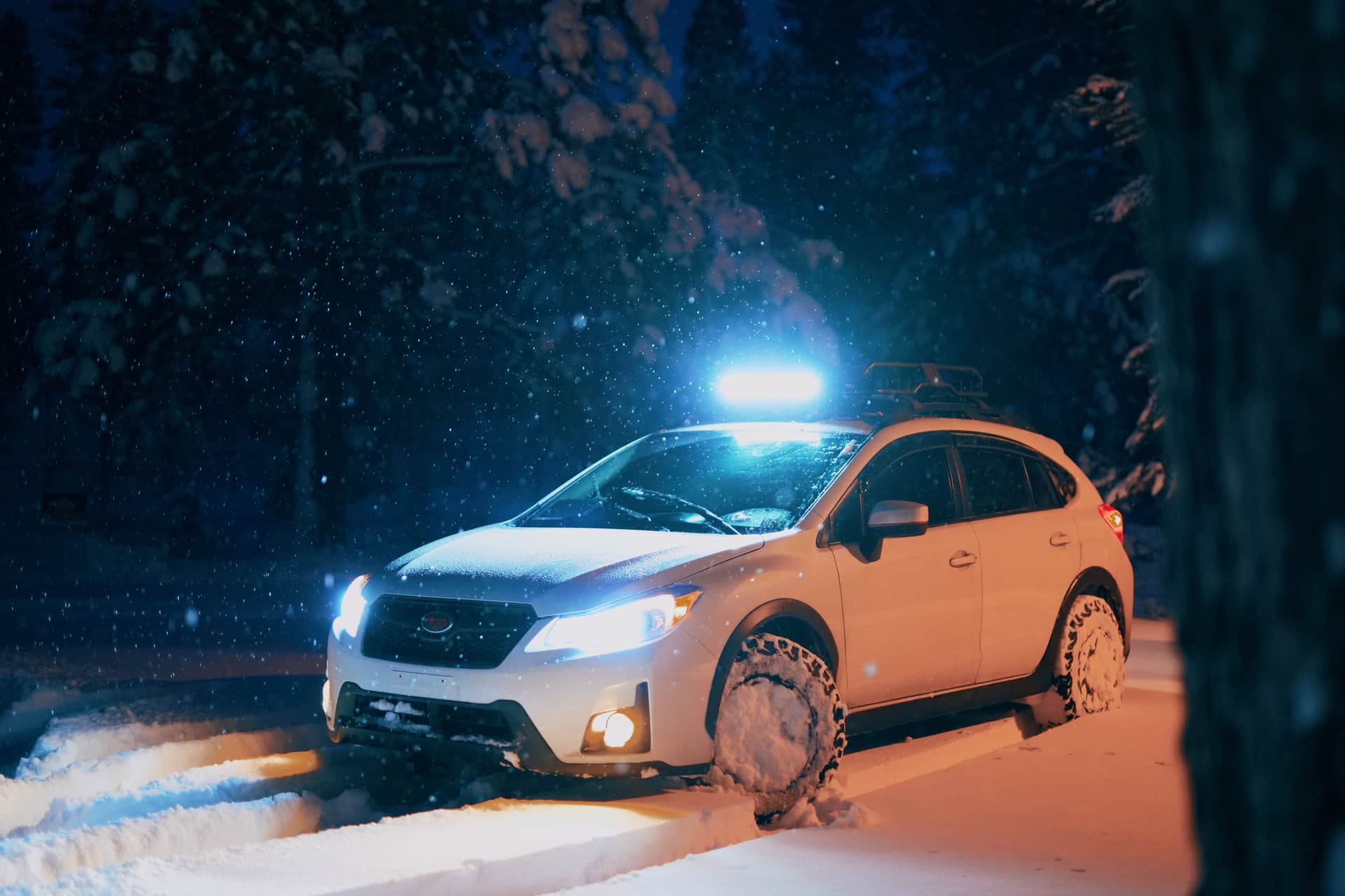 A vehicle on a snow-covered road in low light