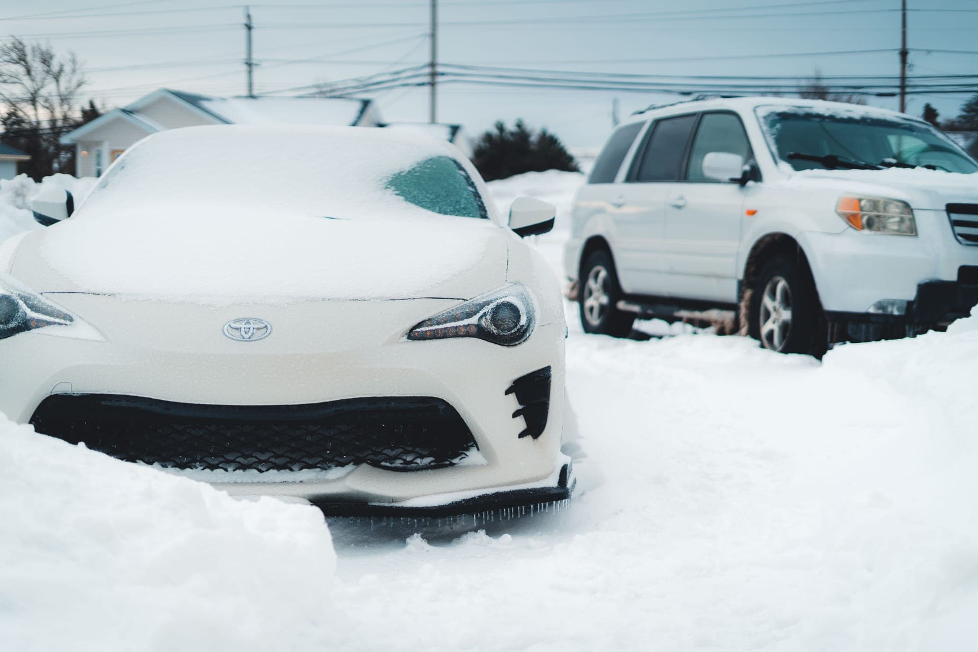 Cars parked outside under fresh snow