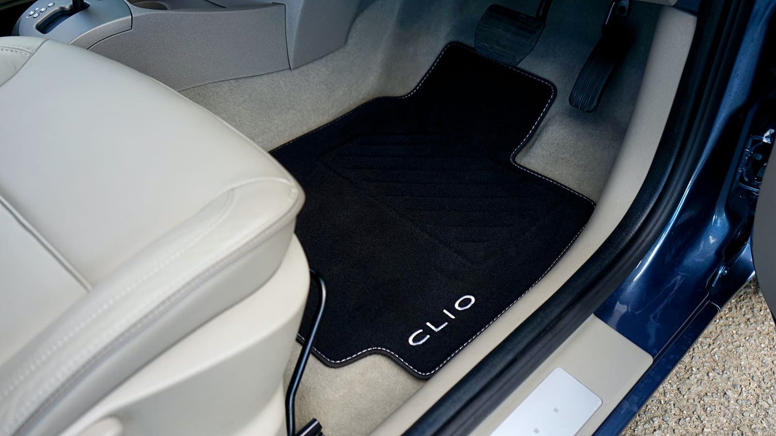 A car floor mat and footwell carpet seen from the open door