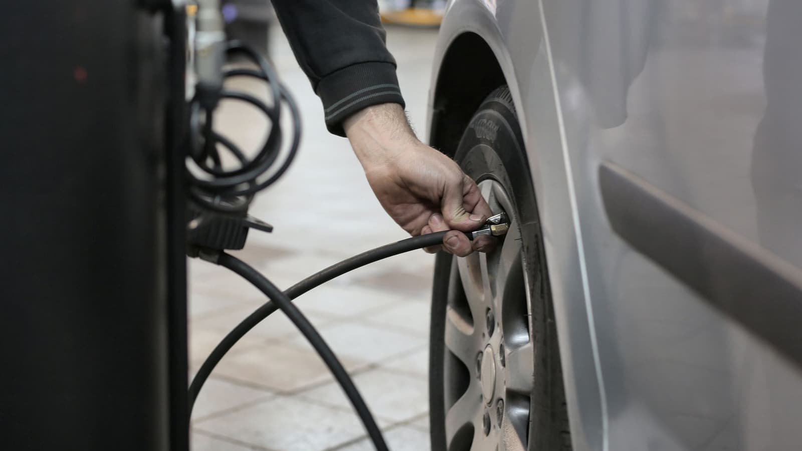 A tire being inflated with a pressure gauge in a workshop
