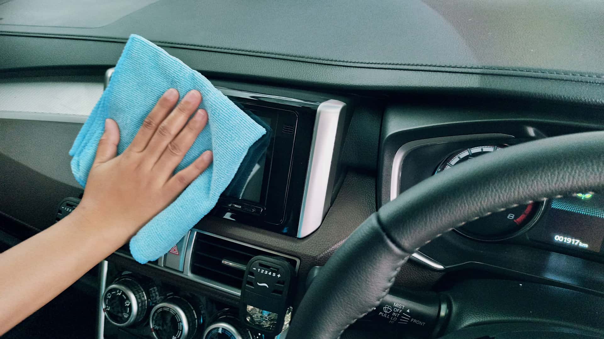 Wiping down a car panel with a cloth