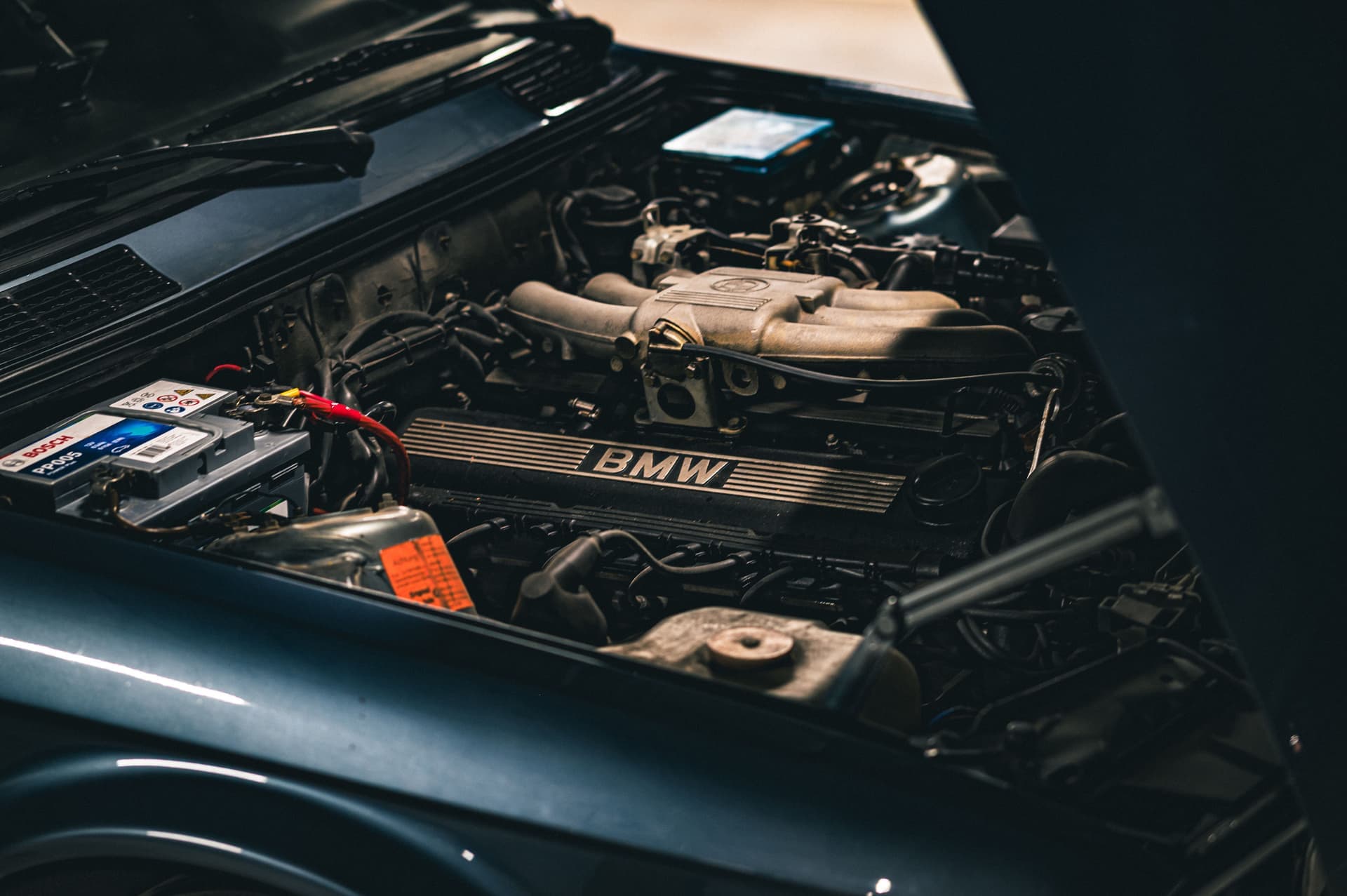 A car engine bay seen close up in a cold garage