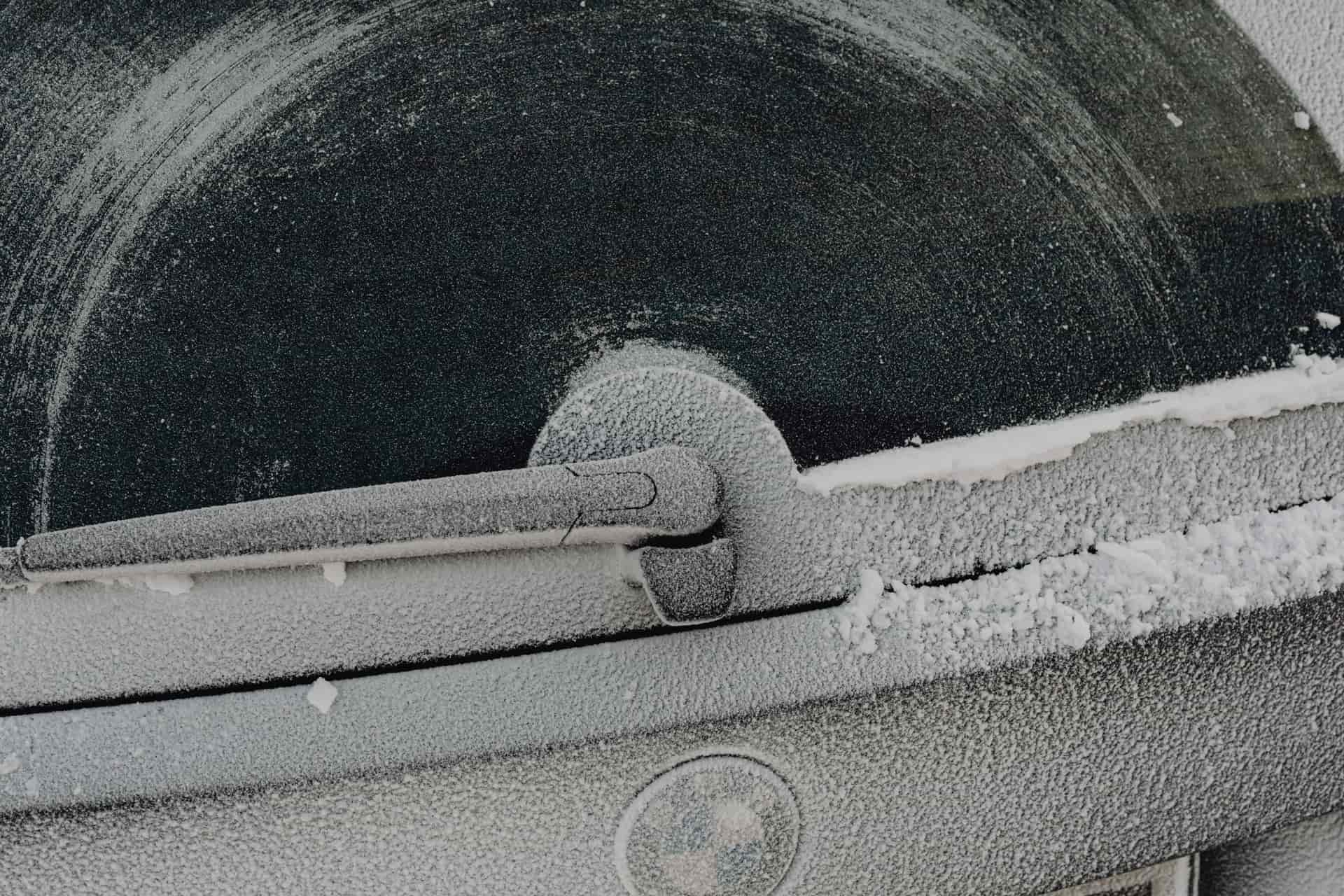 A car window covered in a thick layer of frozen ice
