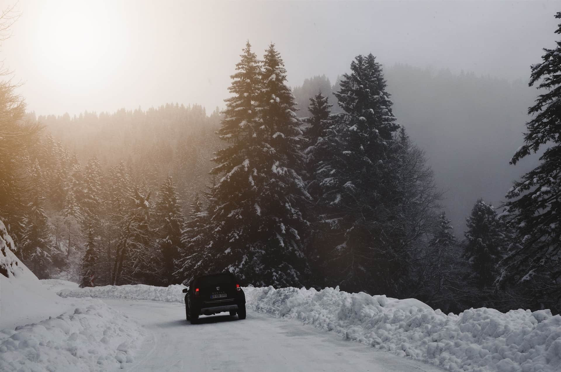 A car on a snow-covered road at first light