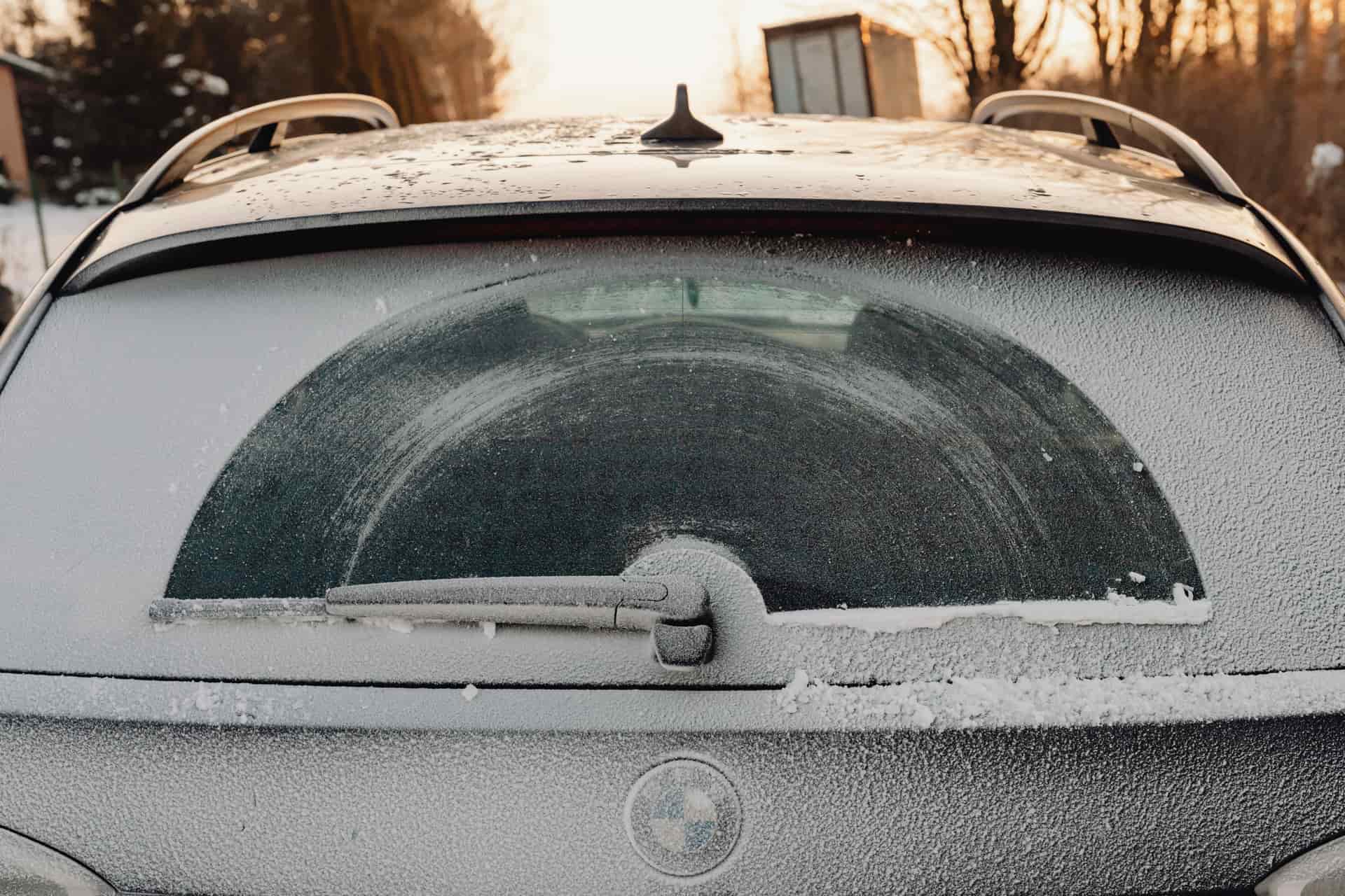 A car window covered in overnight snow and frost